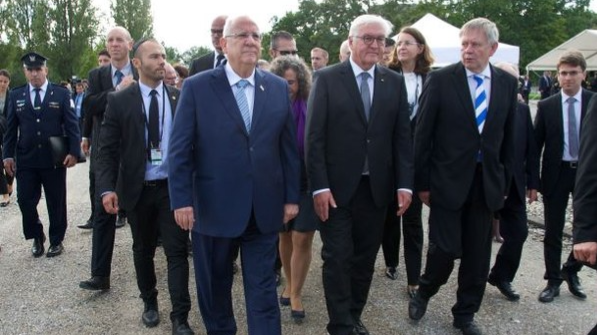Besuch des Israelischen Präsidenten Rivlin und Bundespräsident Steinmeier in Dachau 2017 Mehrere Männer in Anzügen gehen zusammen im Freien, bei einem offiziellen und politischen Anlass (Besuch des Bundespräsidenten und israelischem Präsident). Im Hintergrund sind weitere Personen und grüne Bäume zu sehen.