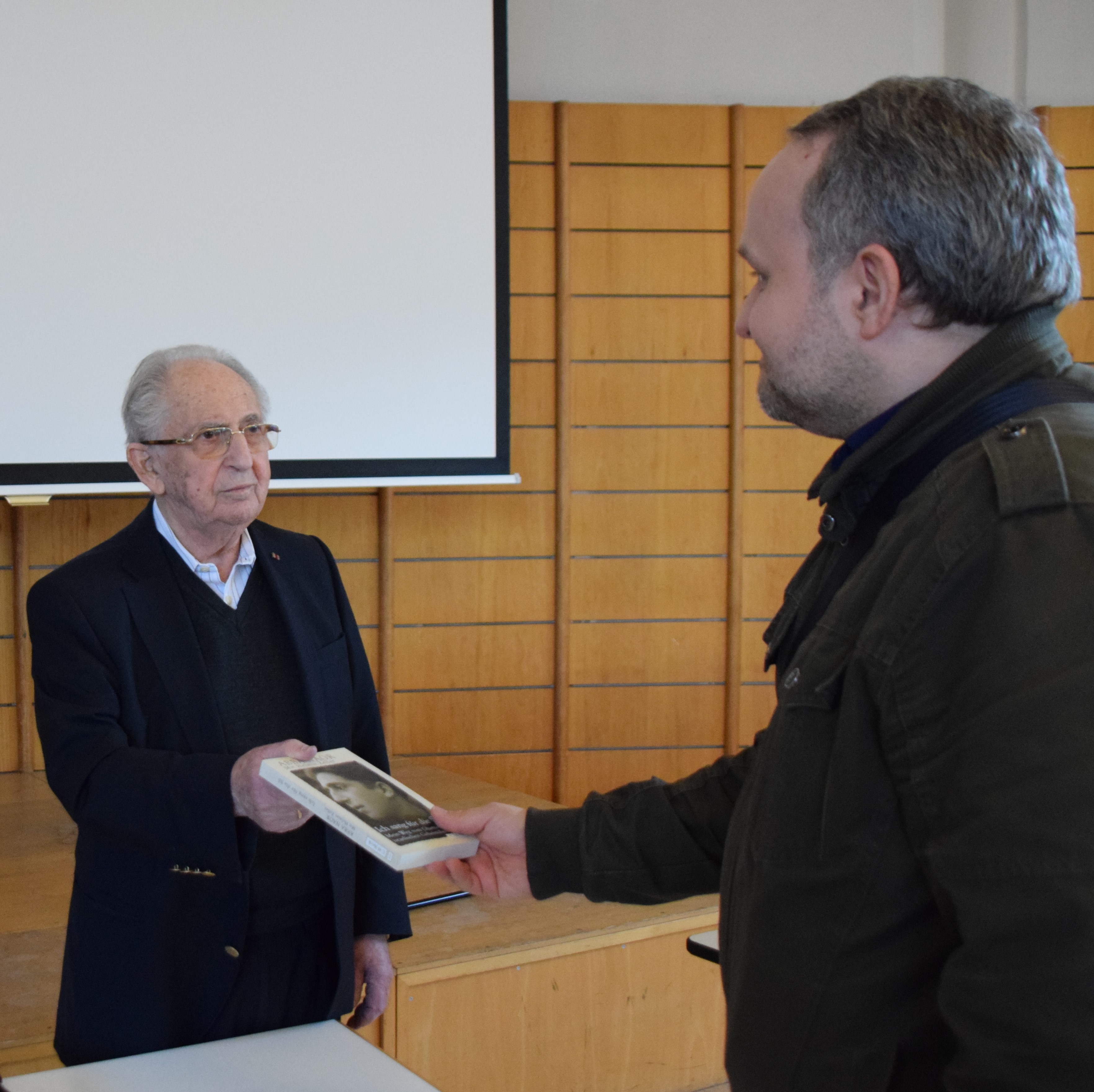 Abba Naor (links im Bild) überreicht einem Lehrer seine Biographie. Foto © Stiftung Bayerische Gedenkstätten / Guido Hassel