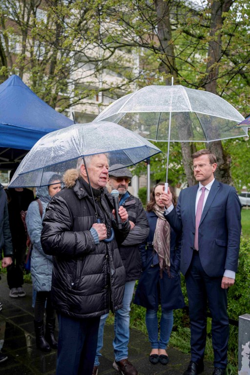 Herr Freller ist mit Schirm und Mikrofon in der Hand, er spricht gerade. Um ihn stehen einige warm angezogene Personen, viele Schirme.